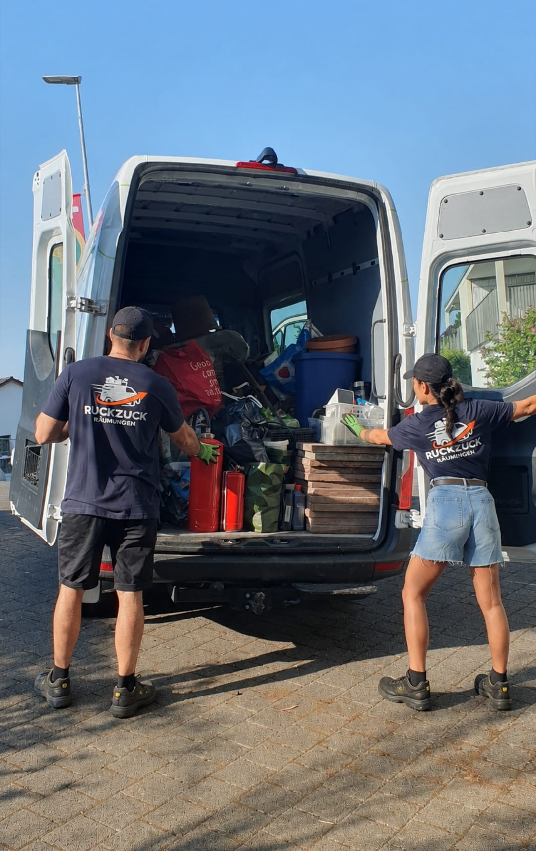 Ruckzuck-Team mit Sicherheitsschuhen beim Beladen des Räumungsfahrzeugs